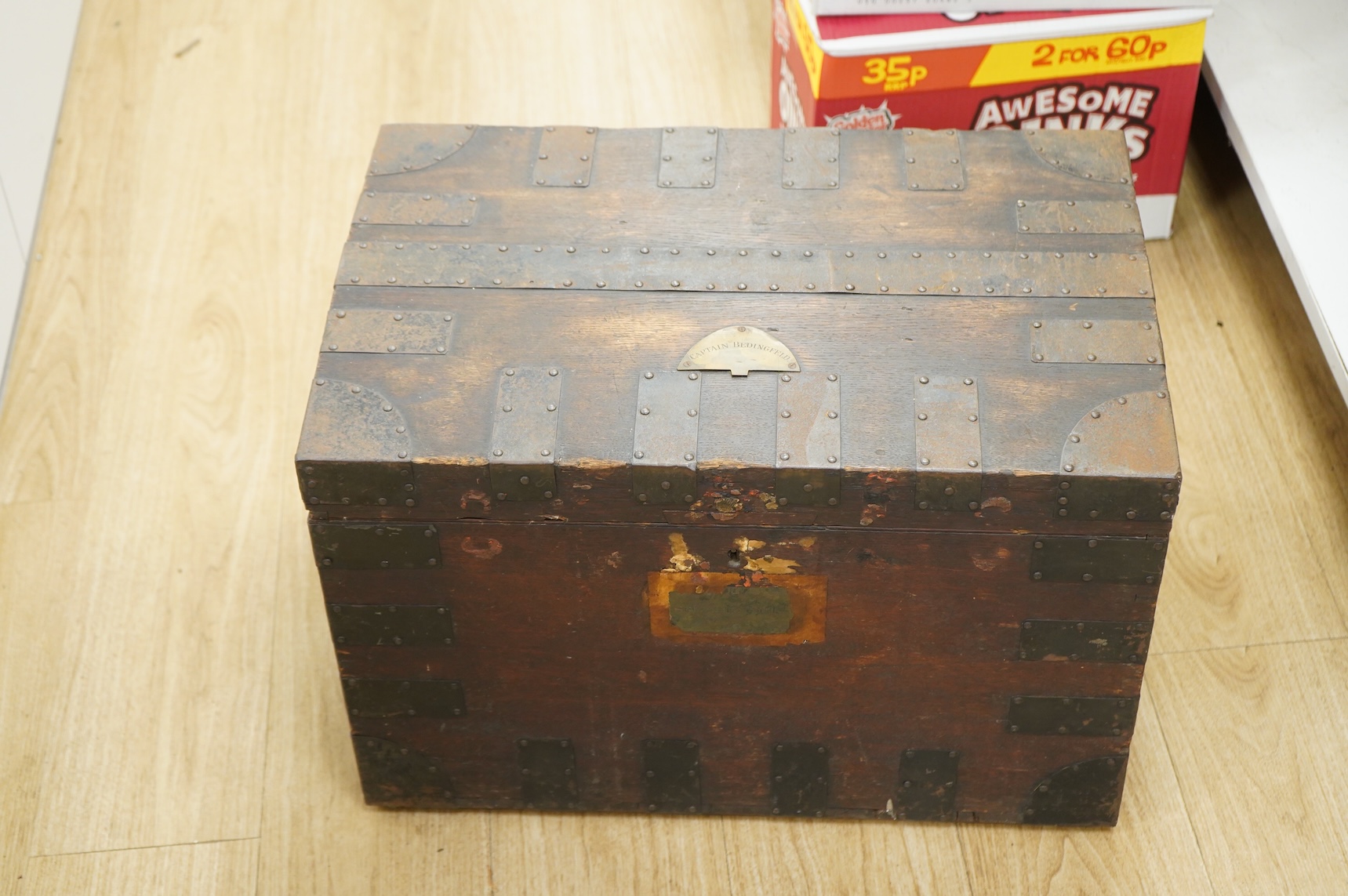 A iron bound oak chest with a fitted interior and removable trays to house an extensive dining set, owned by Captain Norman Bedingfield R.N., with an applied brass plaque to the lid engraved ‘Captain Bedingfield’, togeth